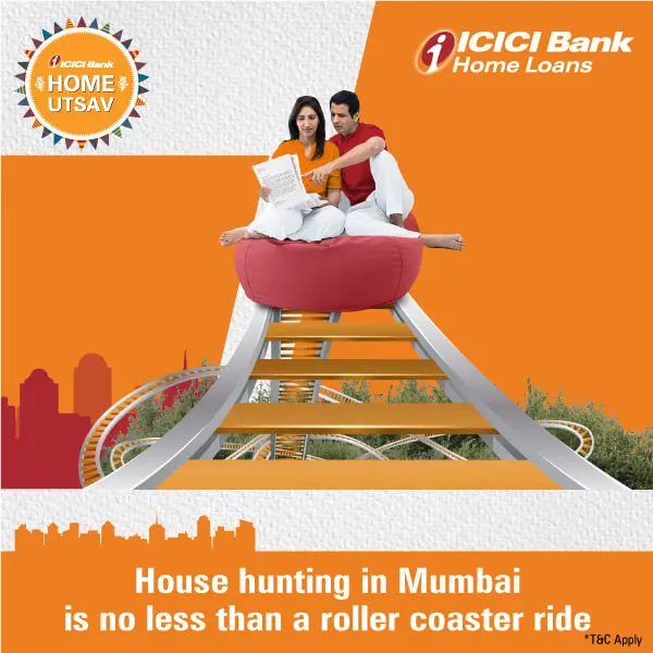 A joyful couple sits together on a large cushion atop roller coaster tracks, symbolizing the excitement of house hunting in Mumbai.
